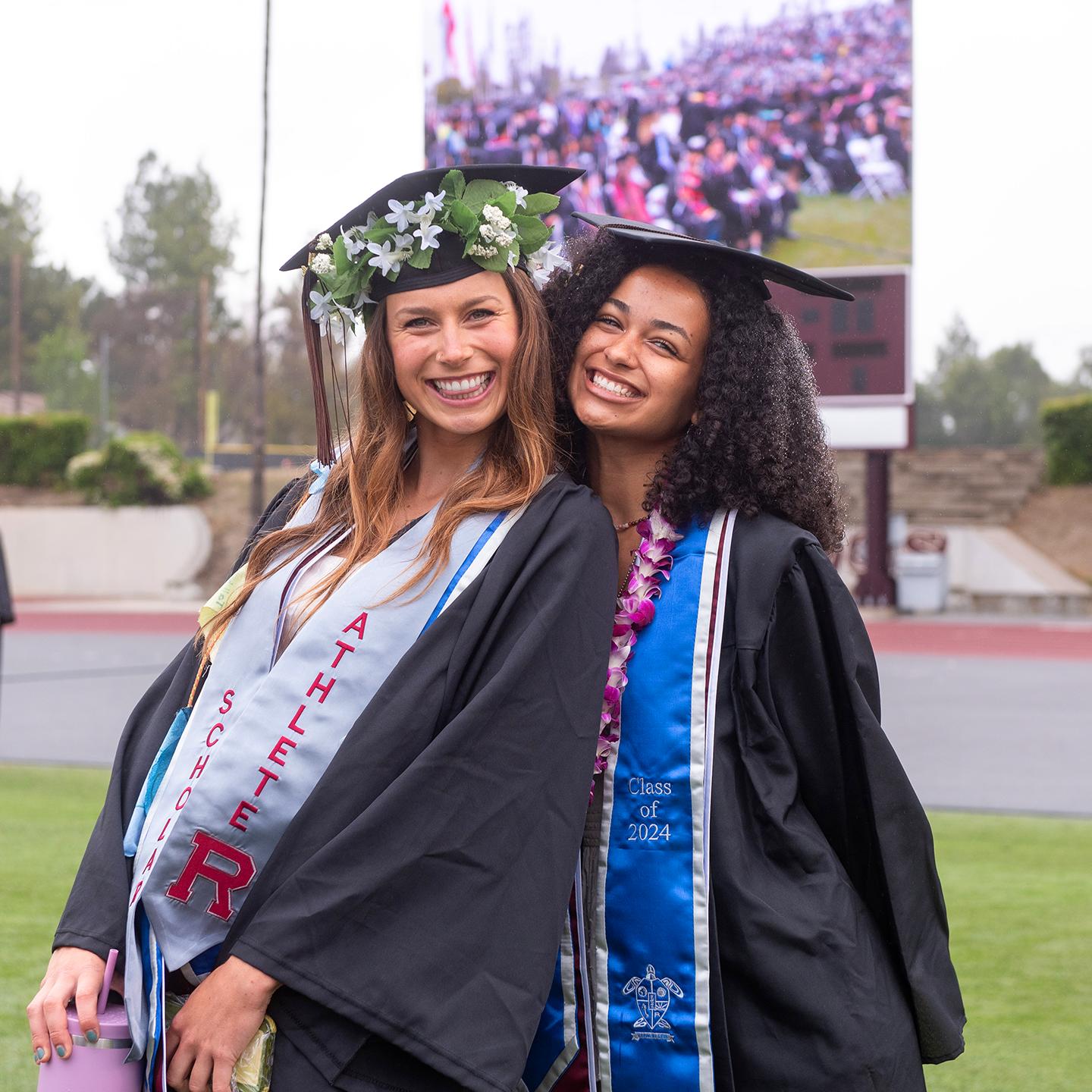 two women in graduation gowns and caps