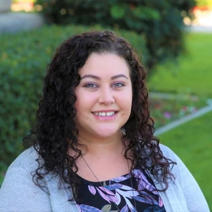 a woman with long curly hair smiling