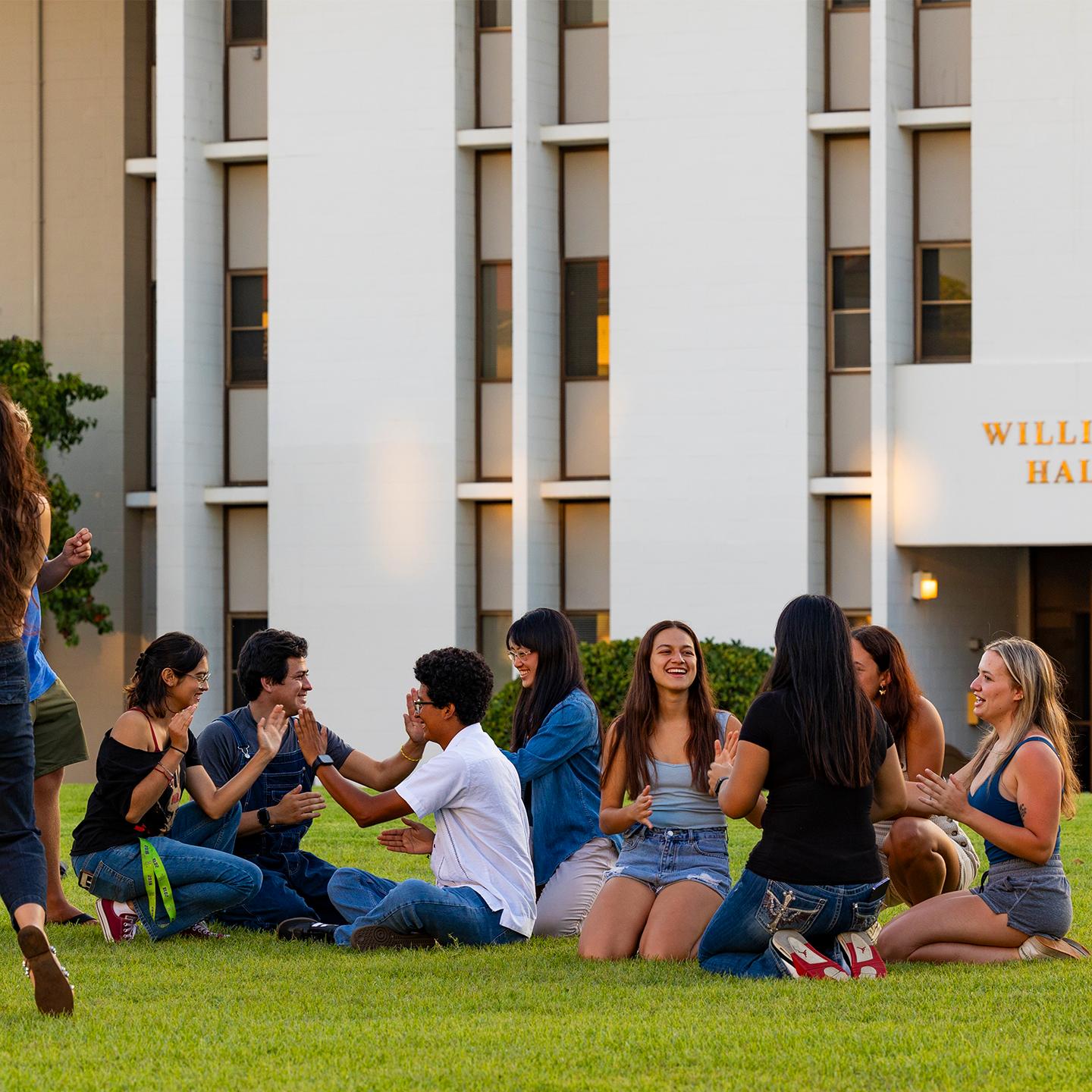 a group of people sitting on the grass
