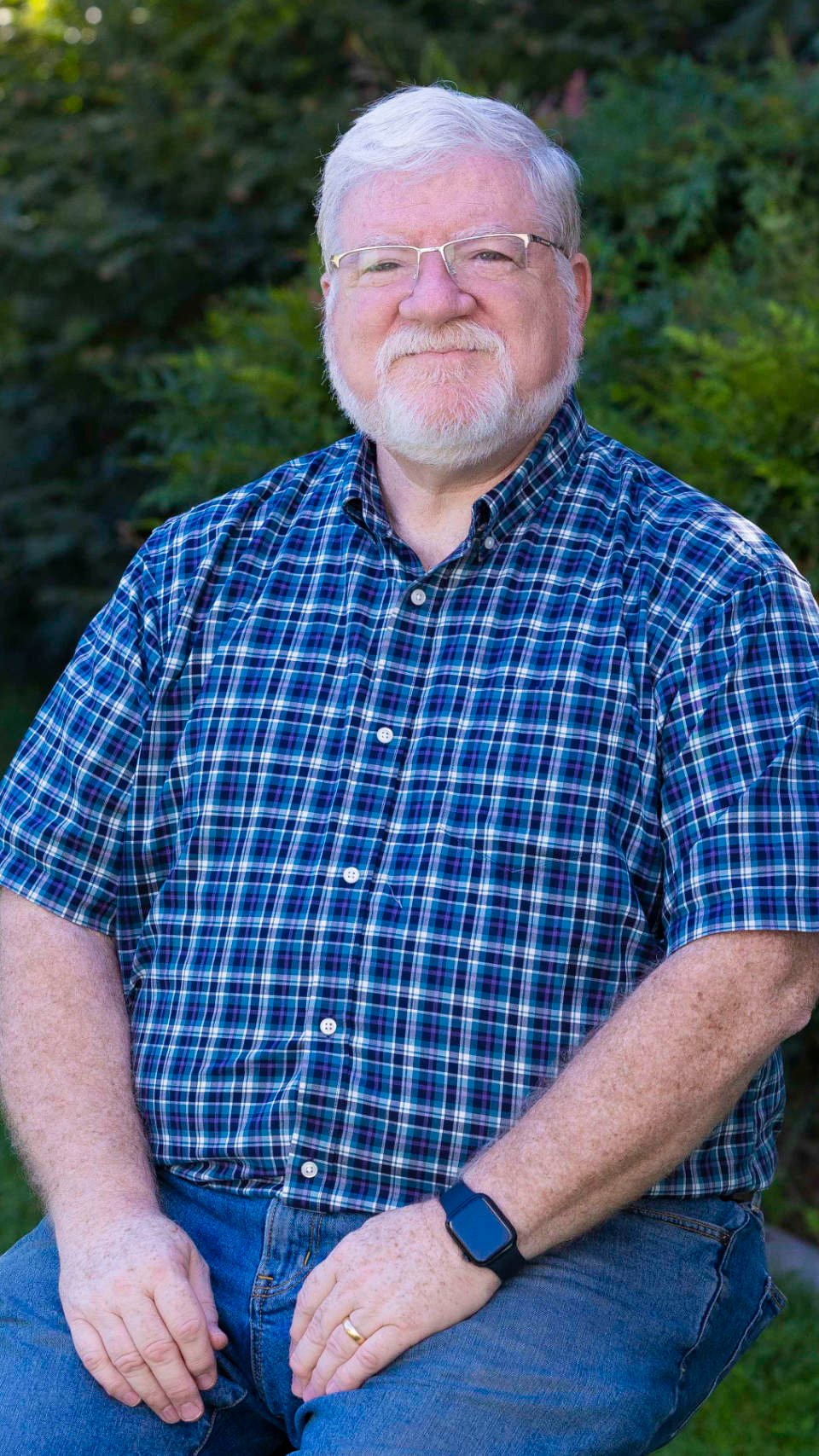 a person with a beard and mustache wearing a blue plaid shirt