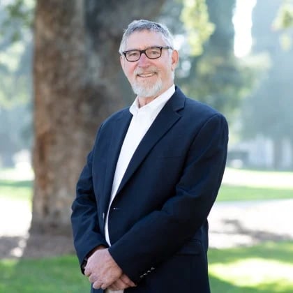 a man in a suit standing in a park