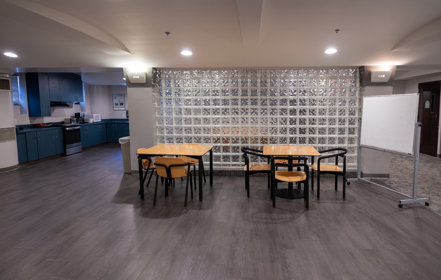 a room with a glass wall and tables and chairs