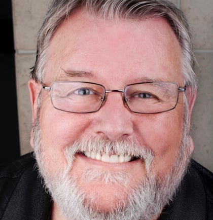 a man with glasses smiling