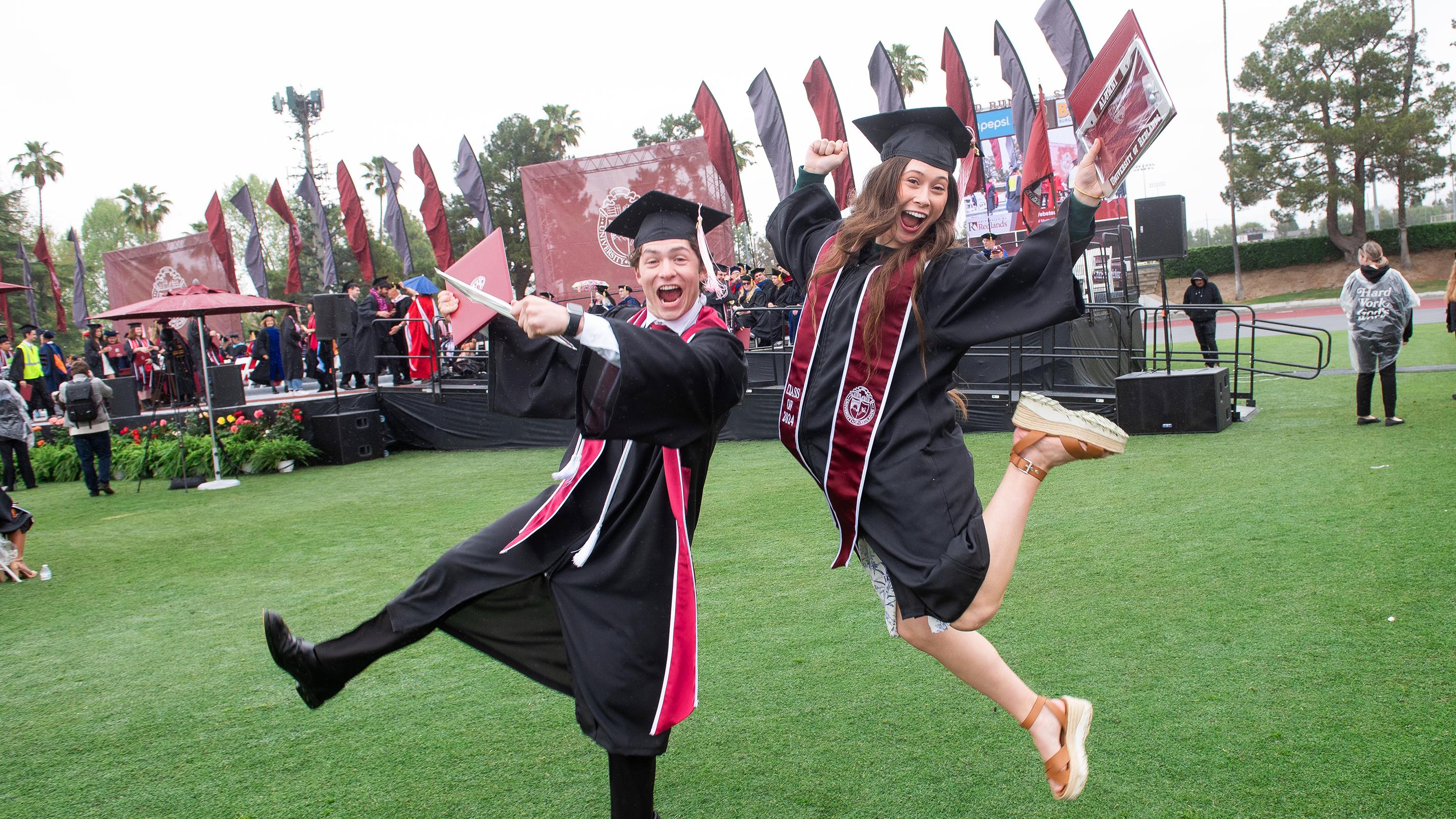 a man and woman in graduation gowns jumping in the air