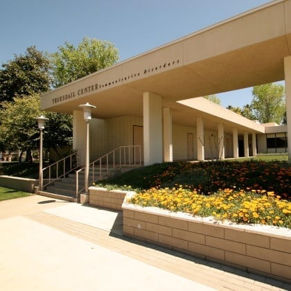 a building with a walkway and flowers