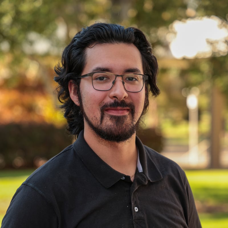 a man with glasses and beard wearing a black shirt
