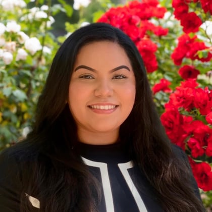 a woman smiling in front of flowers