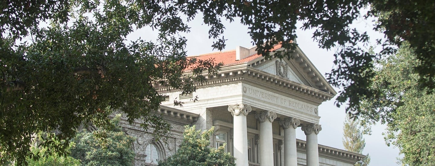 a building with columns and a red roof