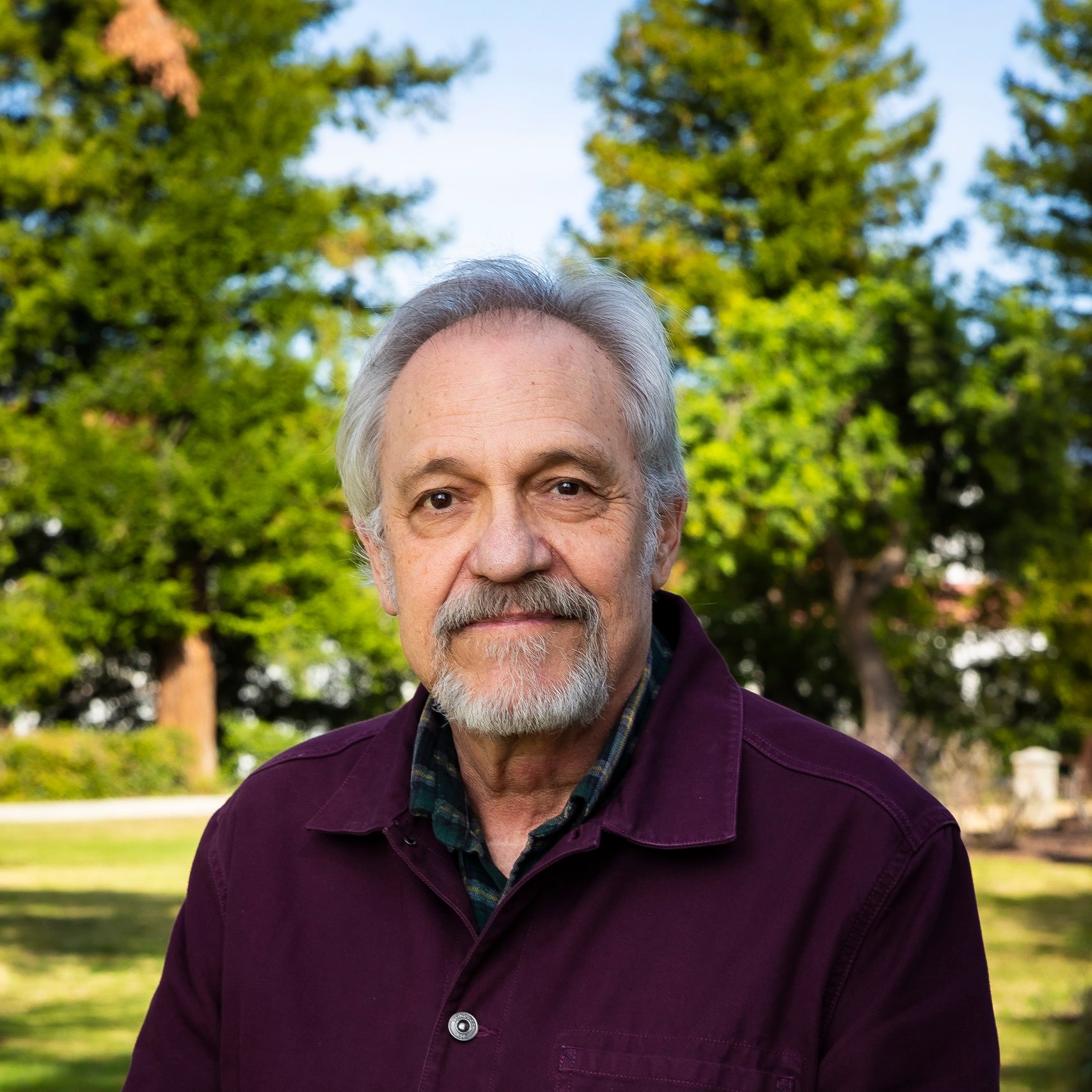 a man with a beard and mustache in a park