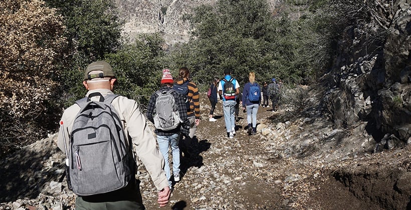 a group of people walking on a rocky path