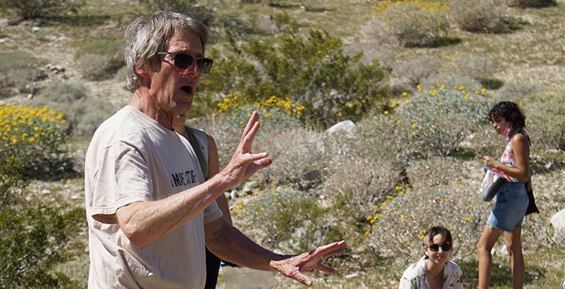 a man in sunglasses standing in front of a group of people