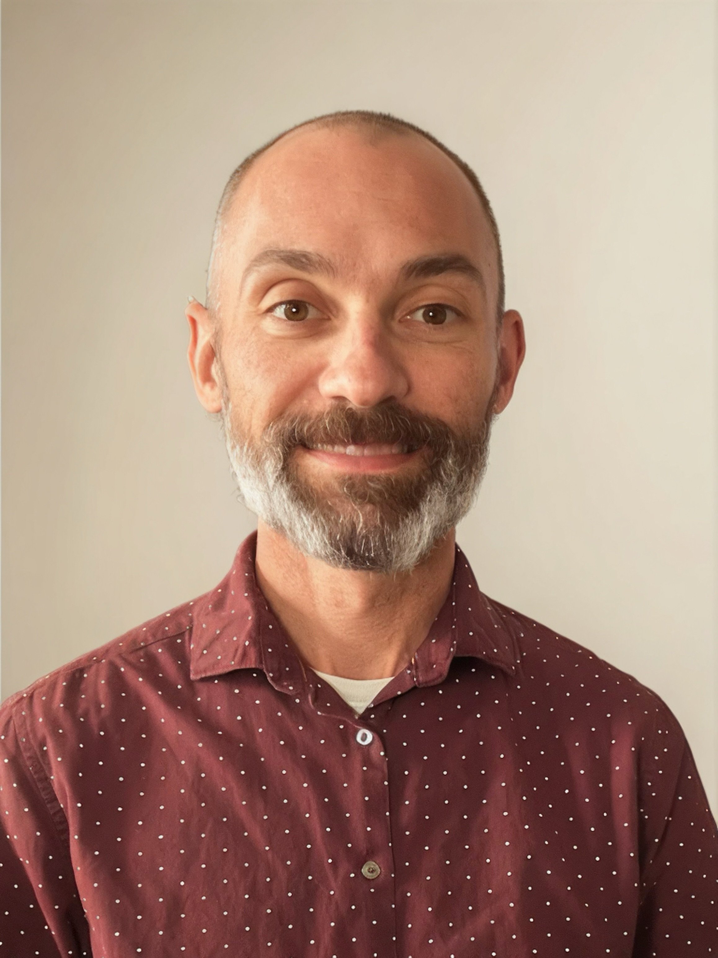a man with a beard and mustache wearing a red shirt