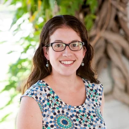 a woman wearing glasses and a blue and white dress