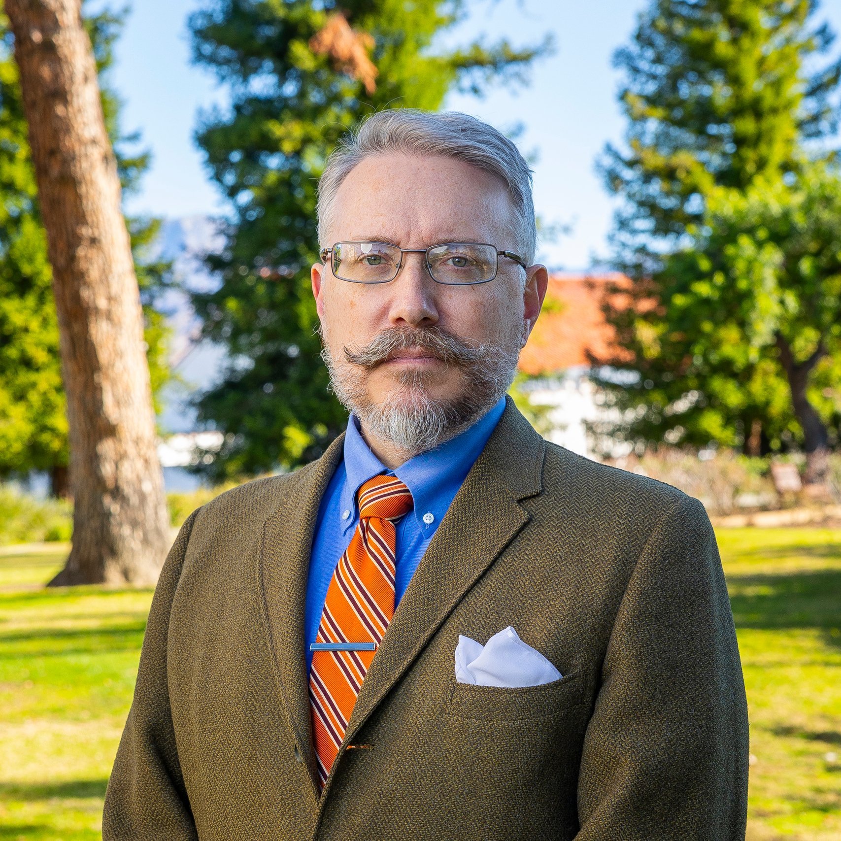 a man with a beard and mustache wearing a suit and tie