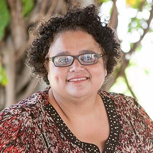 a woman wearing glasses and a patterned shirt