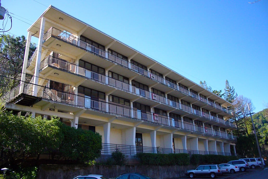 a building with balconies and cars parked in front of it
