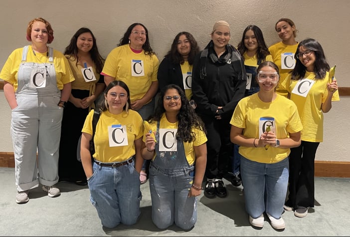 a group of women wearing matching yellow shirts