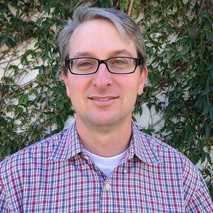 a man wearing glasses and a plaid shirt