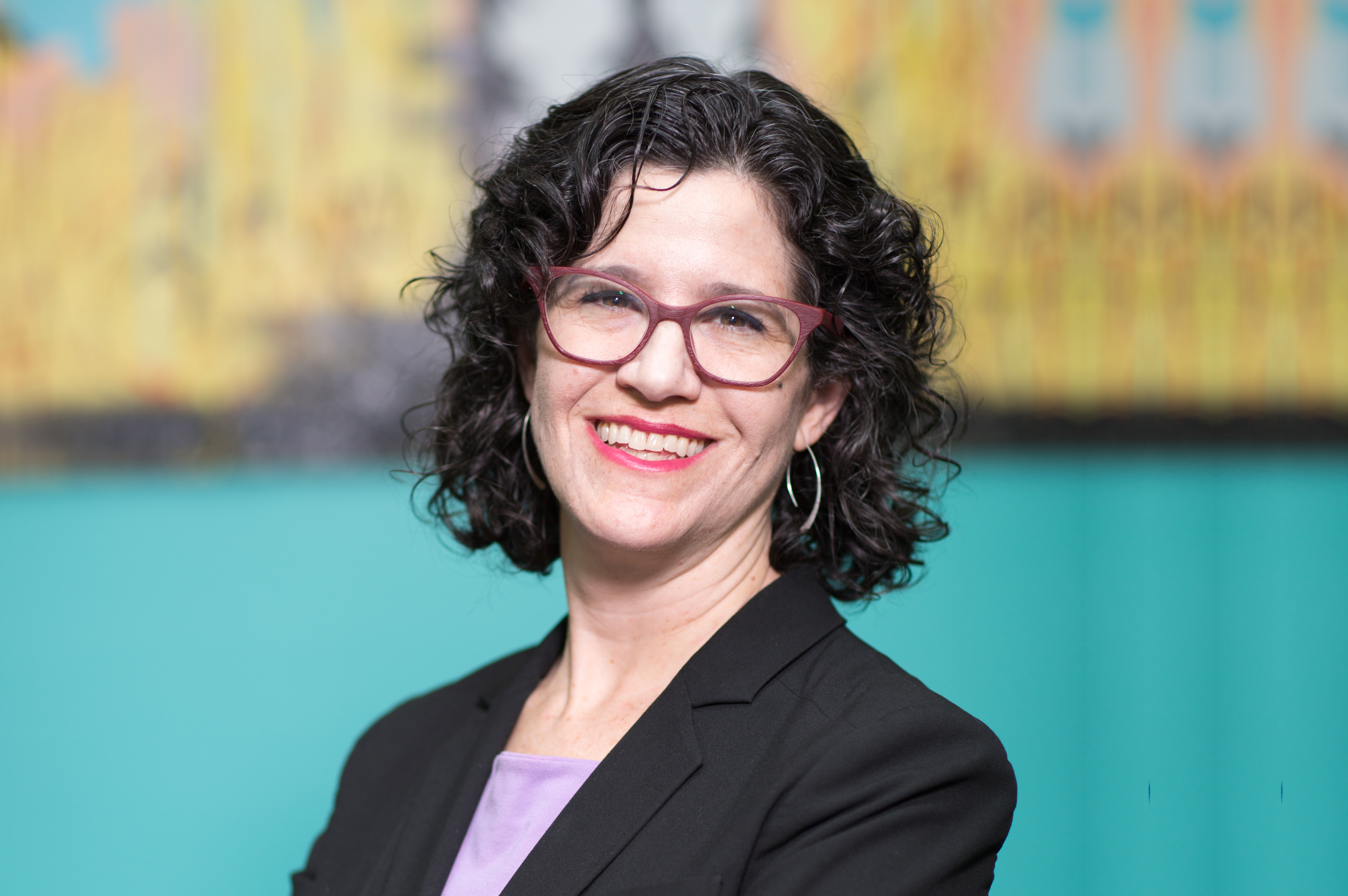 a woman wearing glasses and a black jacket