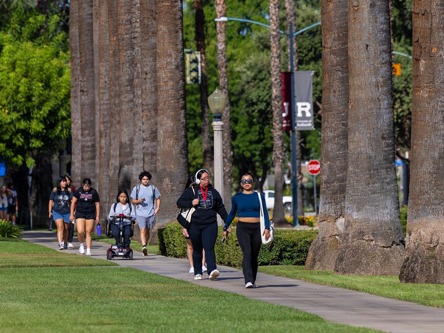 a group of people walking on a sidewalk