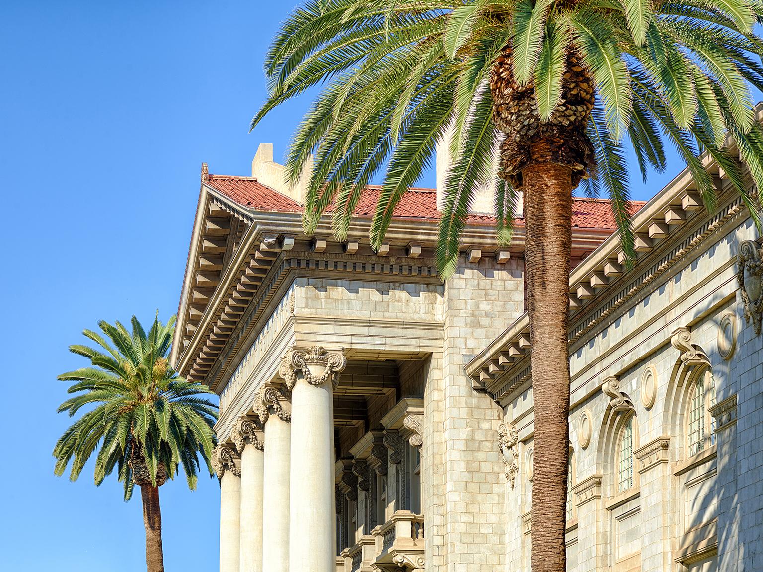 a building with columns and palm trees