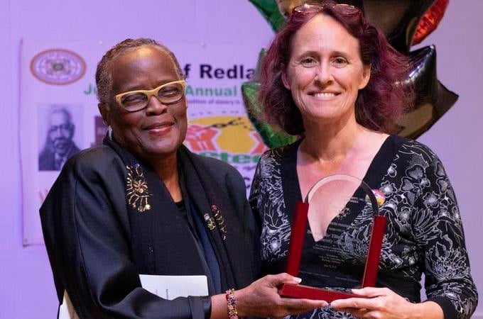 two women holding a trophy