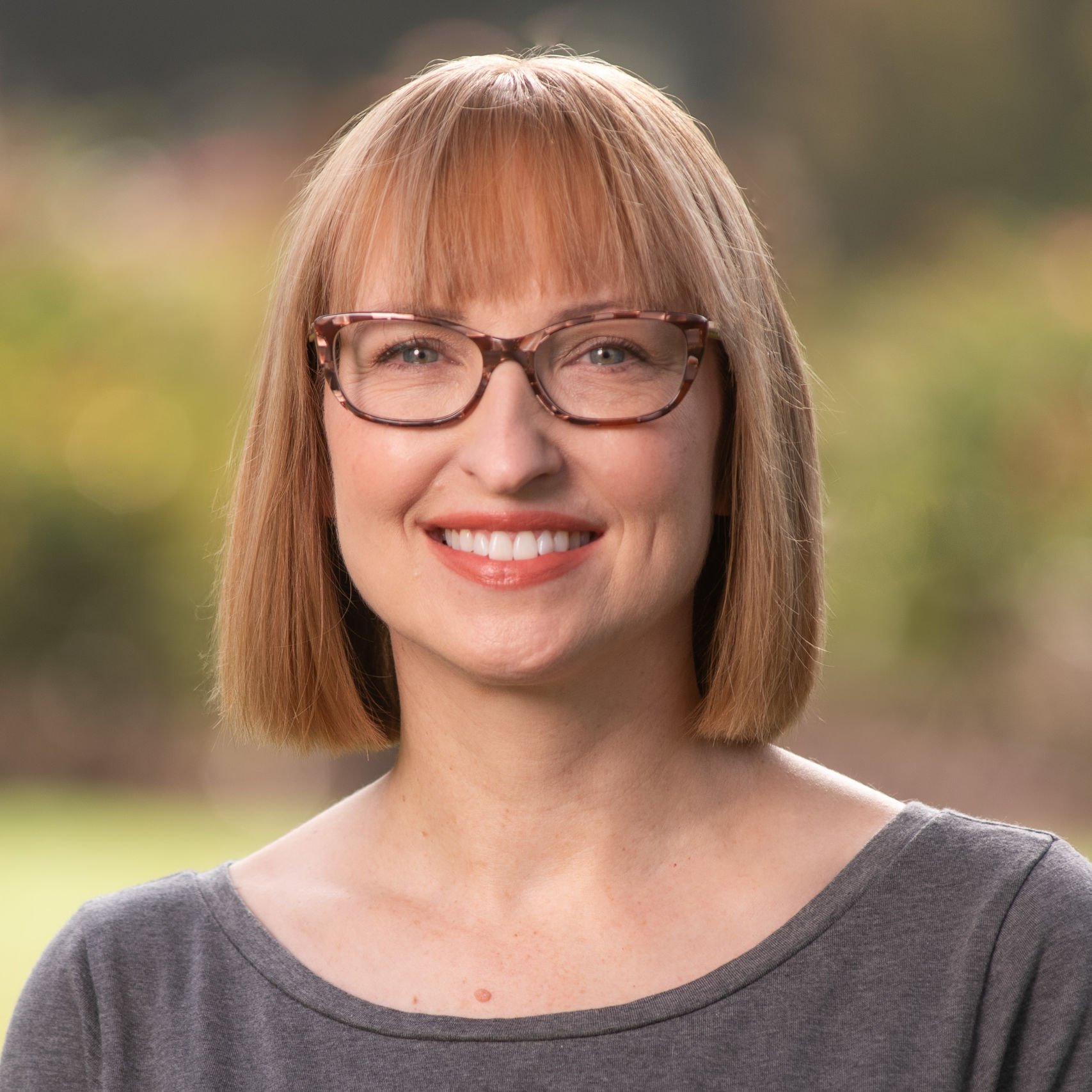 a woman with short hair wearing glasses