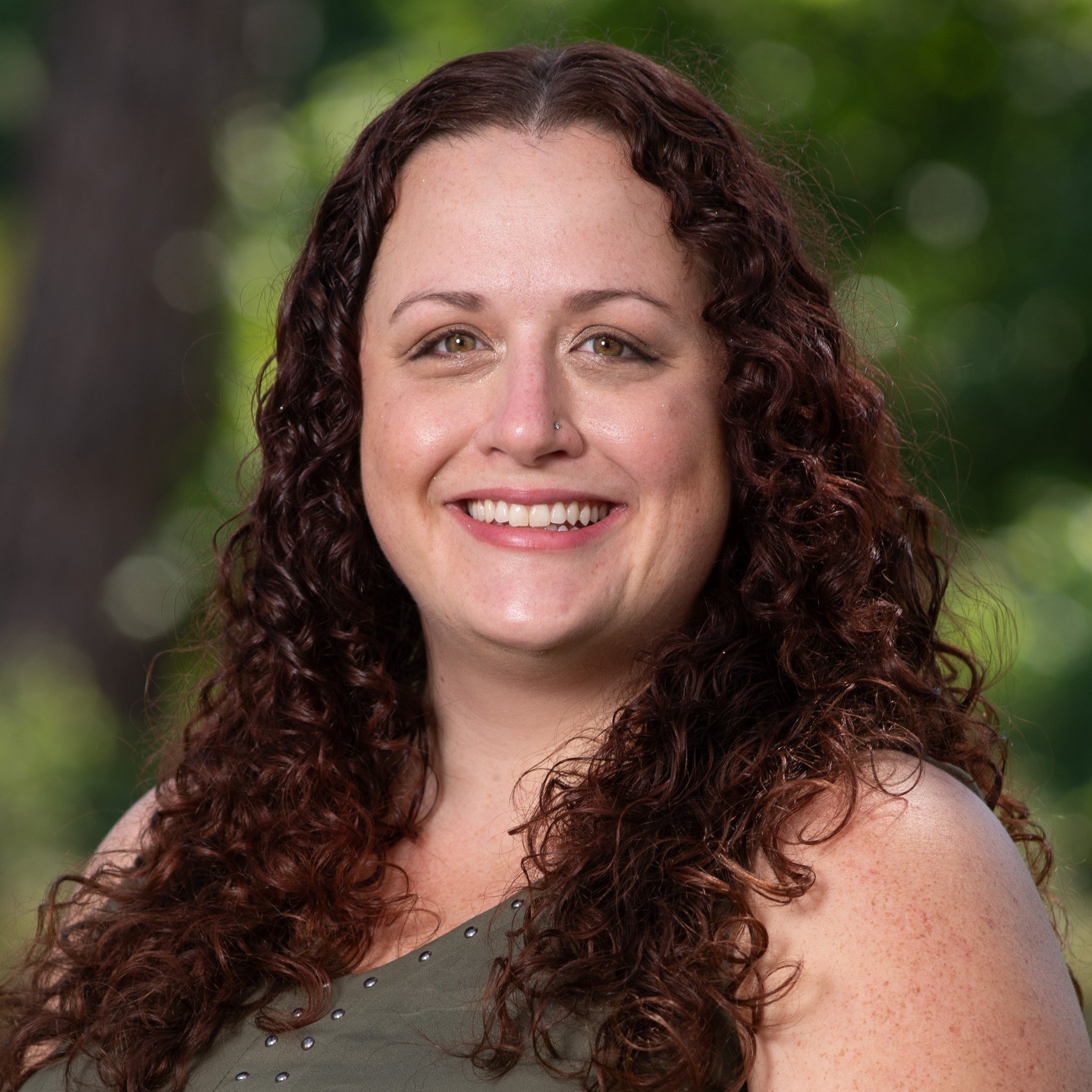 a woman with long curly hair smiling
