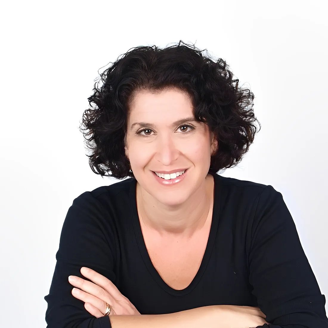 a woman with black hair and arms crossed