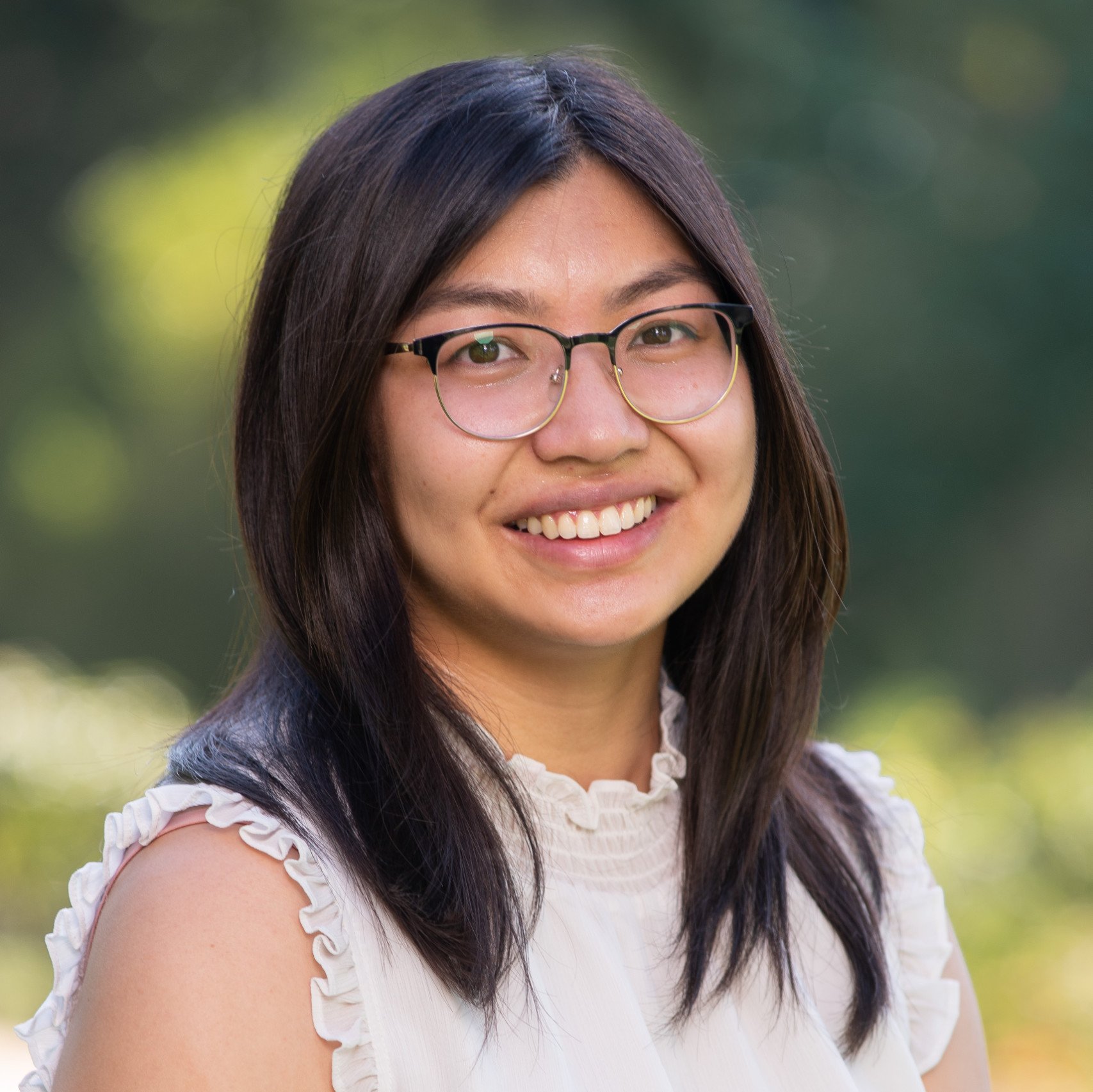 a woman wearing glasses smiling