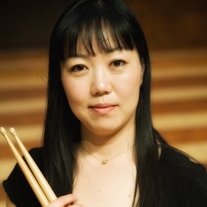 a woman holding drumsticks in her hand