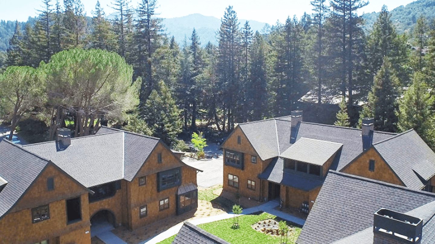 a group of houses with trees in the background