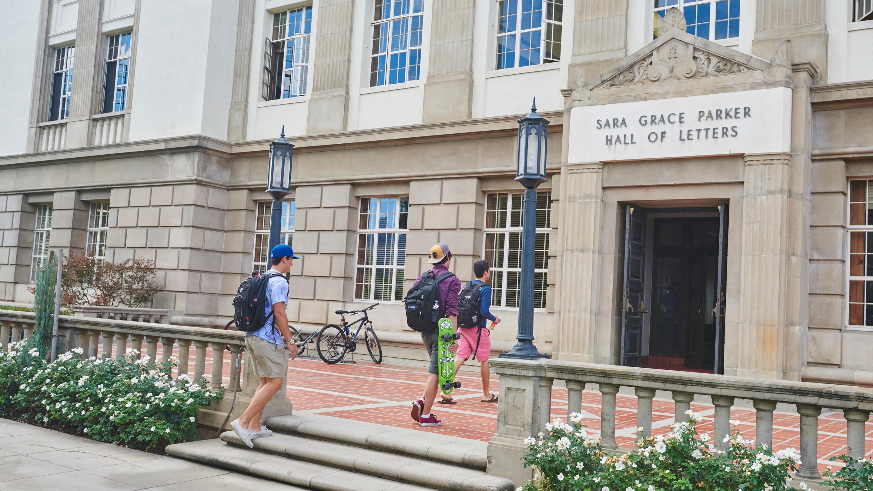 a group of people walking up stairs in front of a building