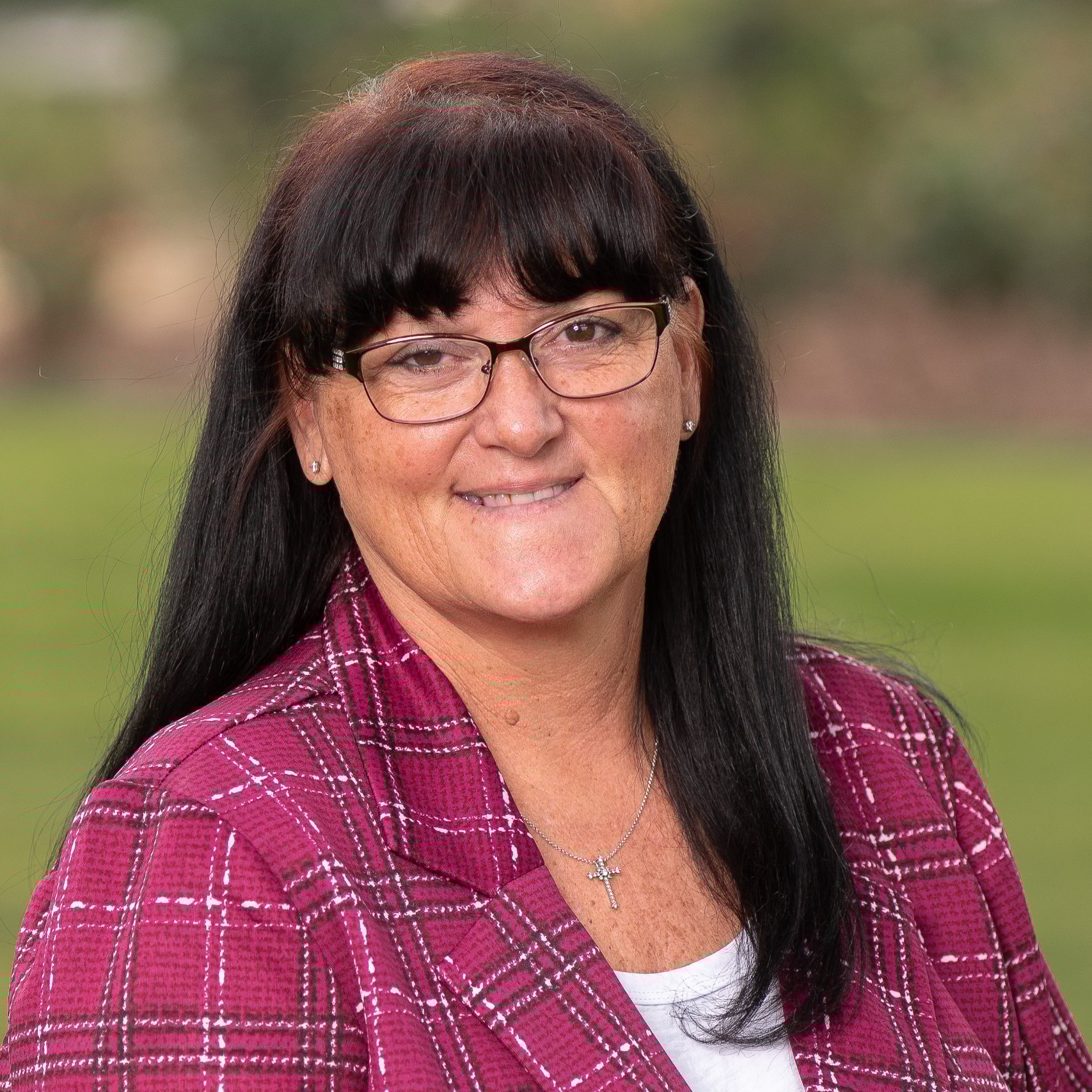 a woman wearing glasses and a red plaid jacket