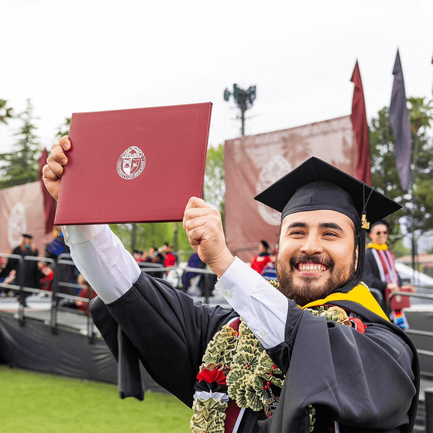 a man in a graduation gown holding a diploma