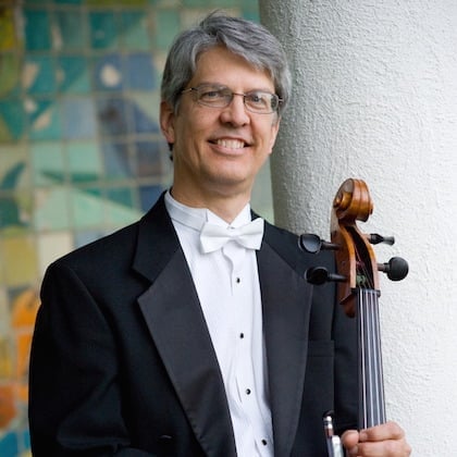 a man in a tuxedo holding a violin