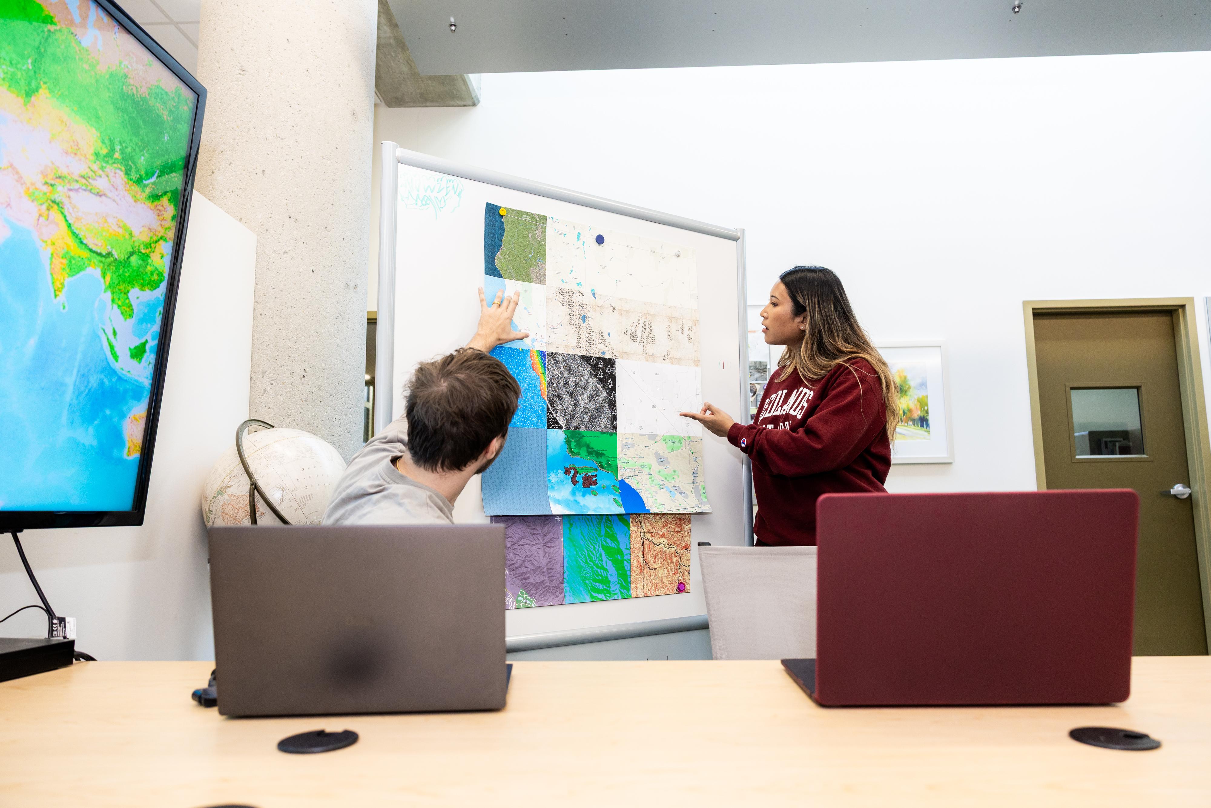 a woman pointing at a white board