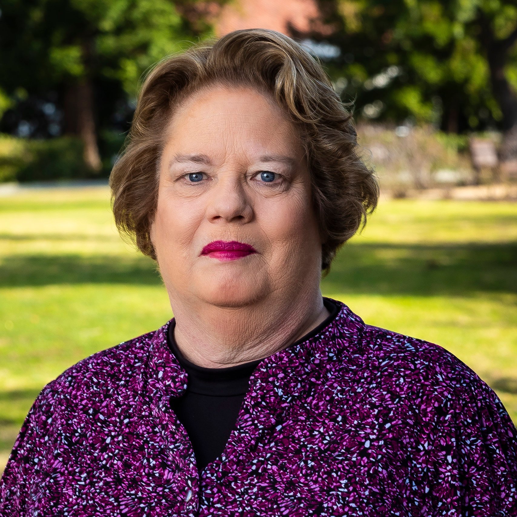 a woman with short hair wearing a purple shirt