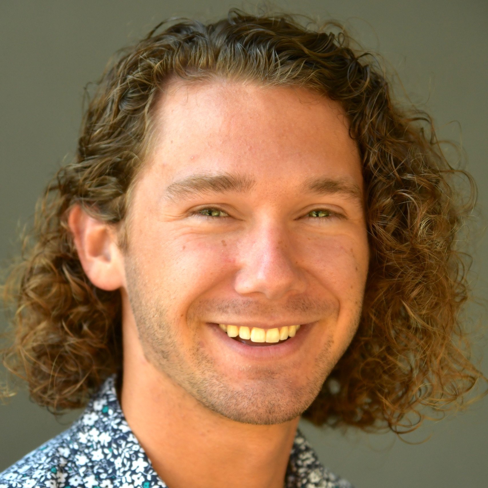 a man with curly hair smiling