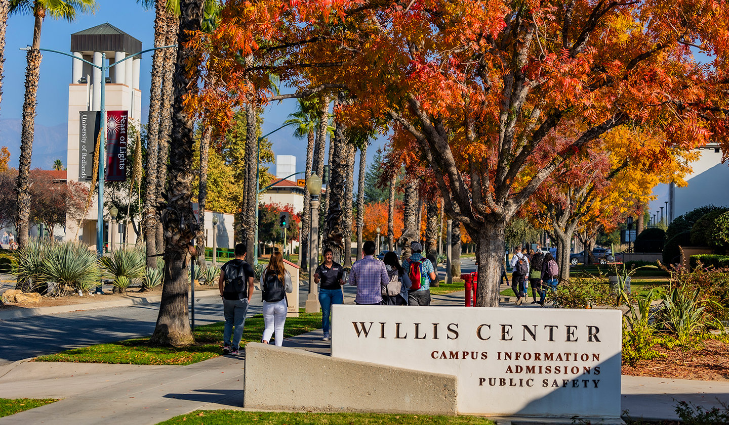 a group of people walking in front of a sign