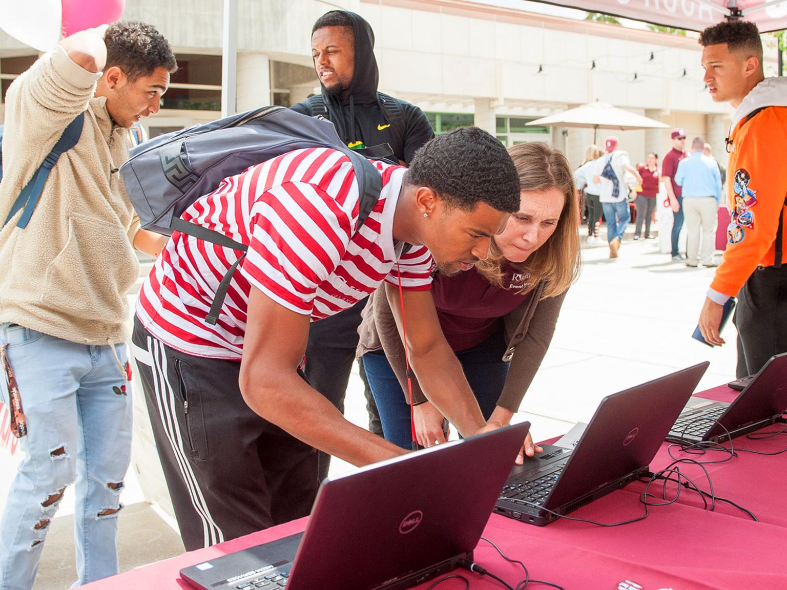 a group of people looking at laptops