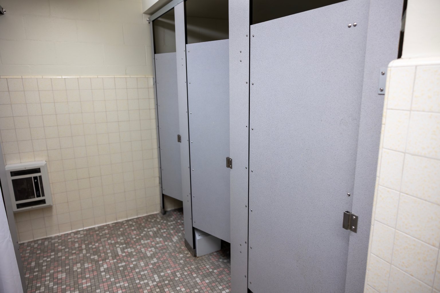 a row of grey doors in a bathroom