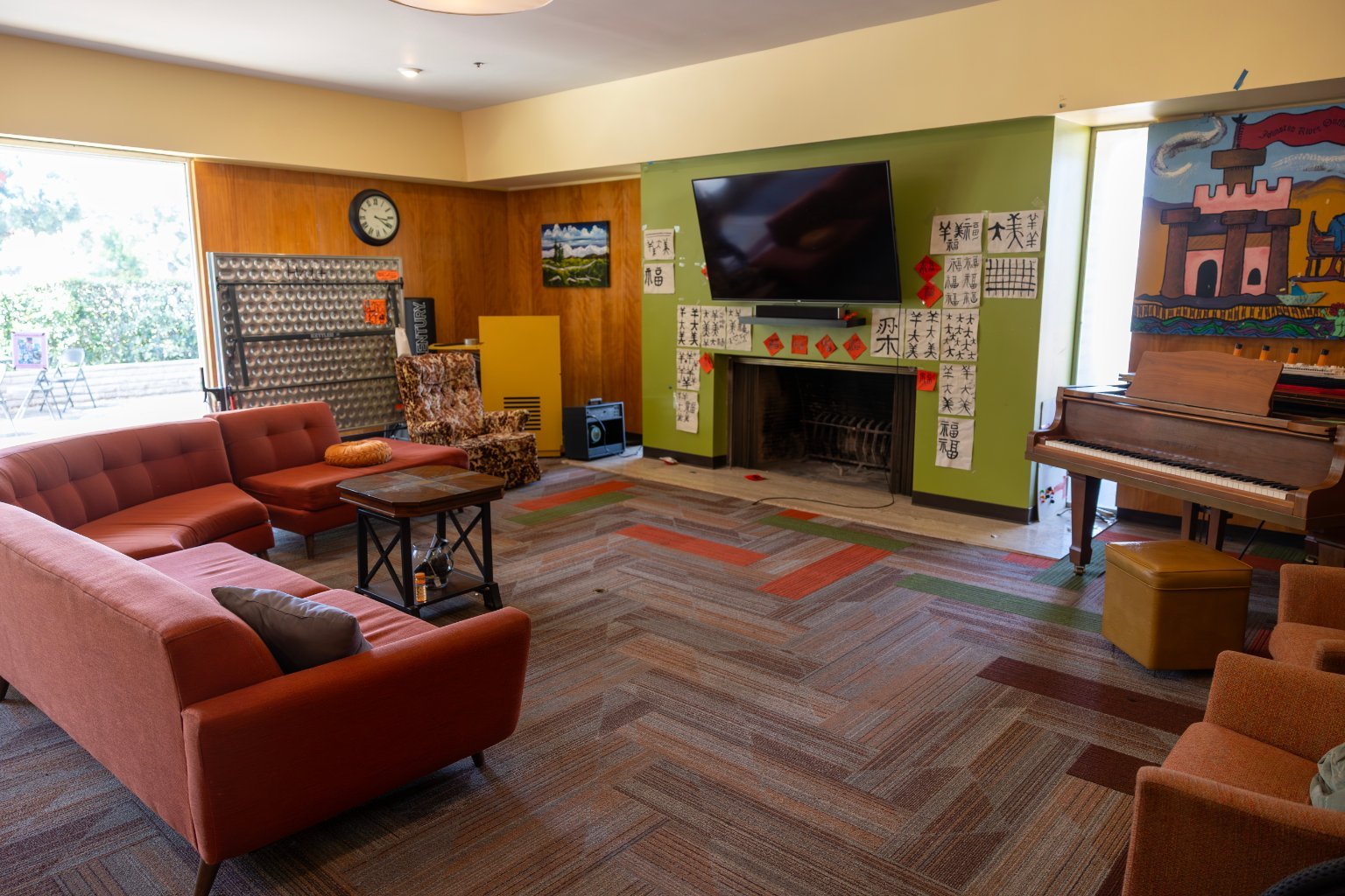 a living room with a piano and couches