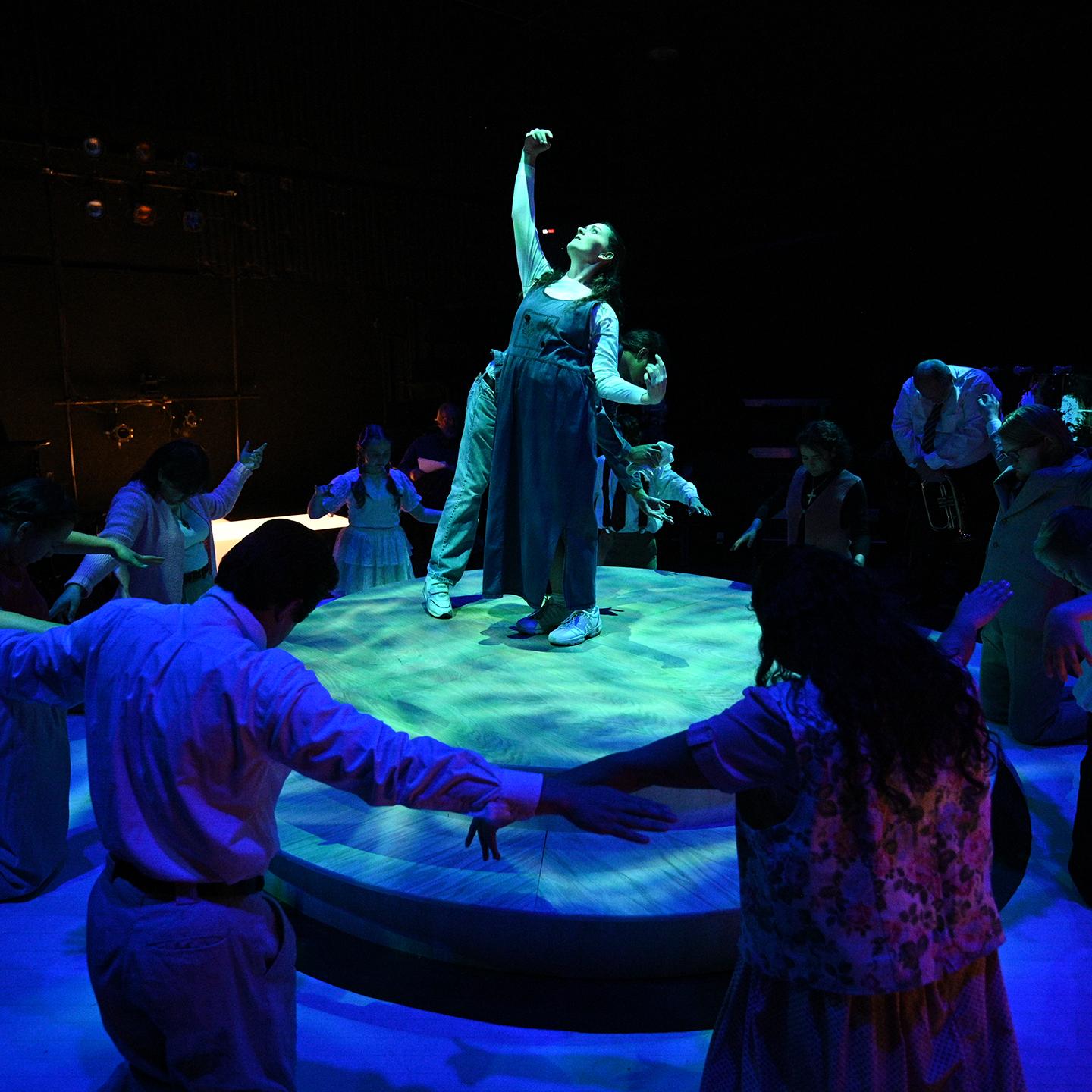 a group of people around a woman on a stage