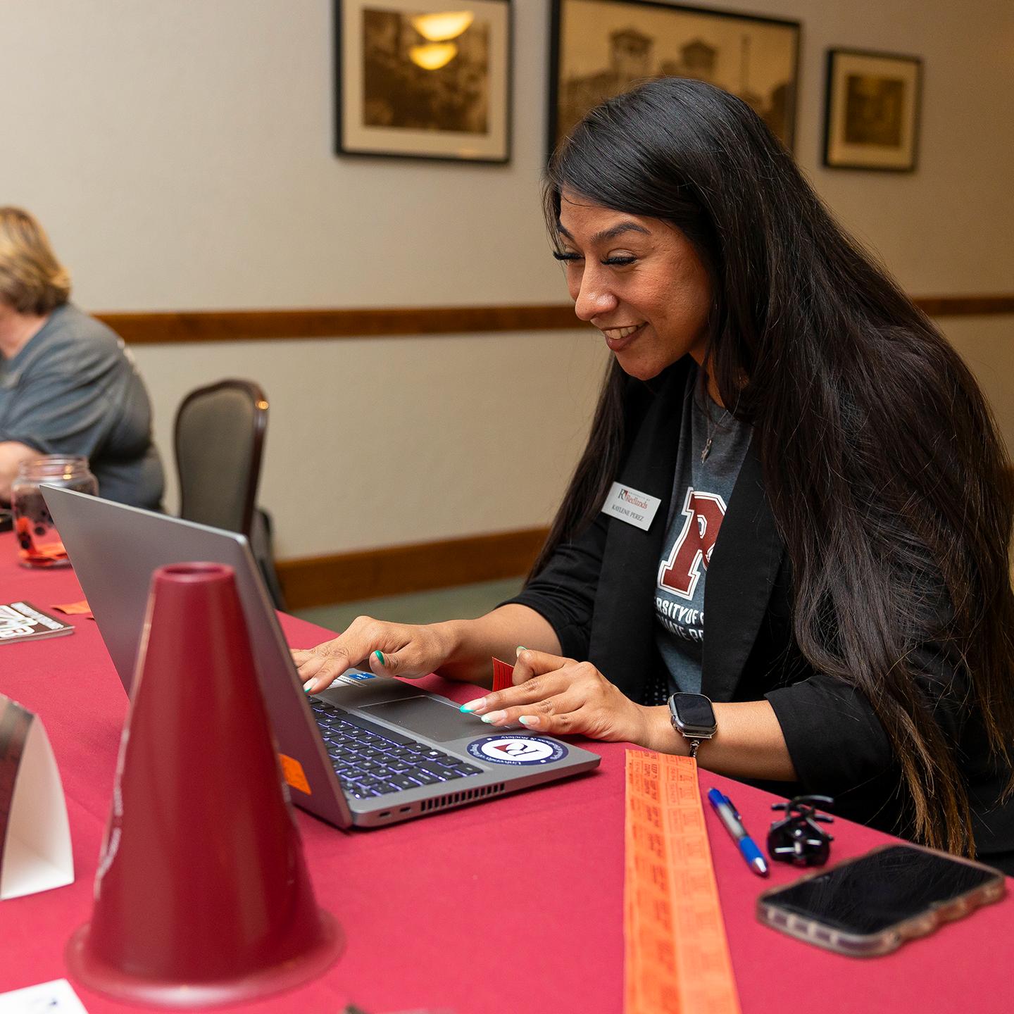 a woman sitting at a table using a laptop