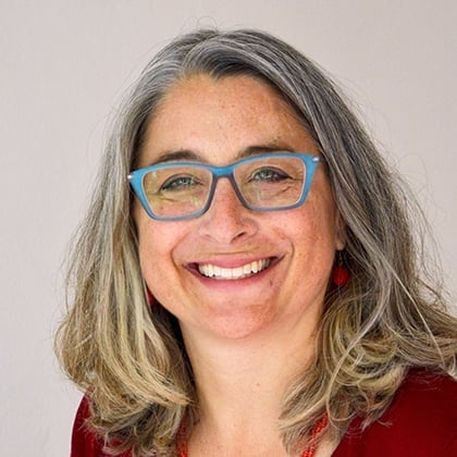 a woman with glasses smiling