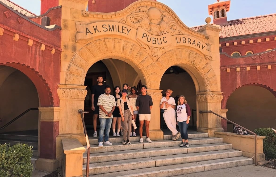 a group of people standing on stairs in front of a library