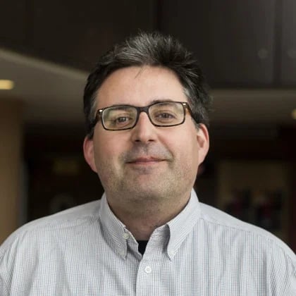 a man wearing glasses and a button up shirt