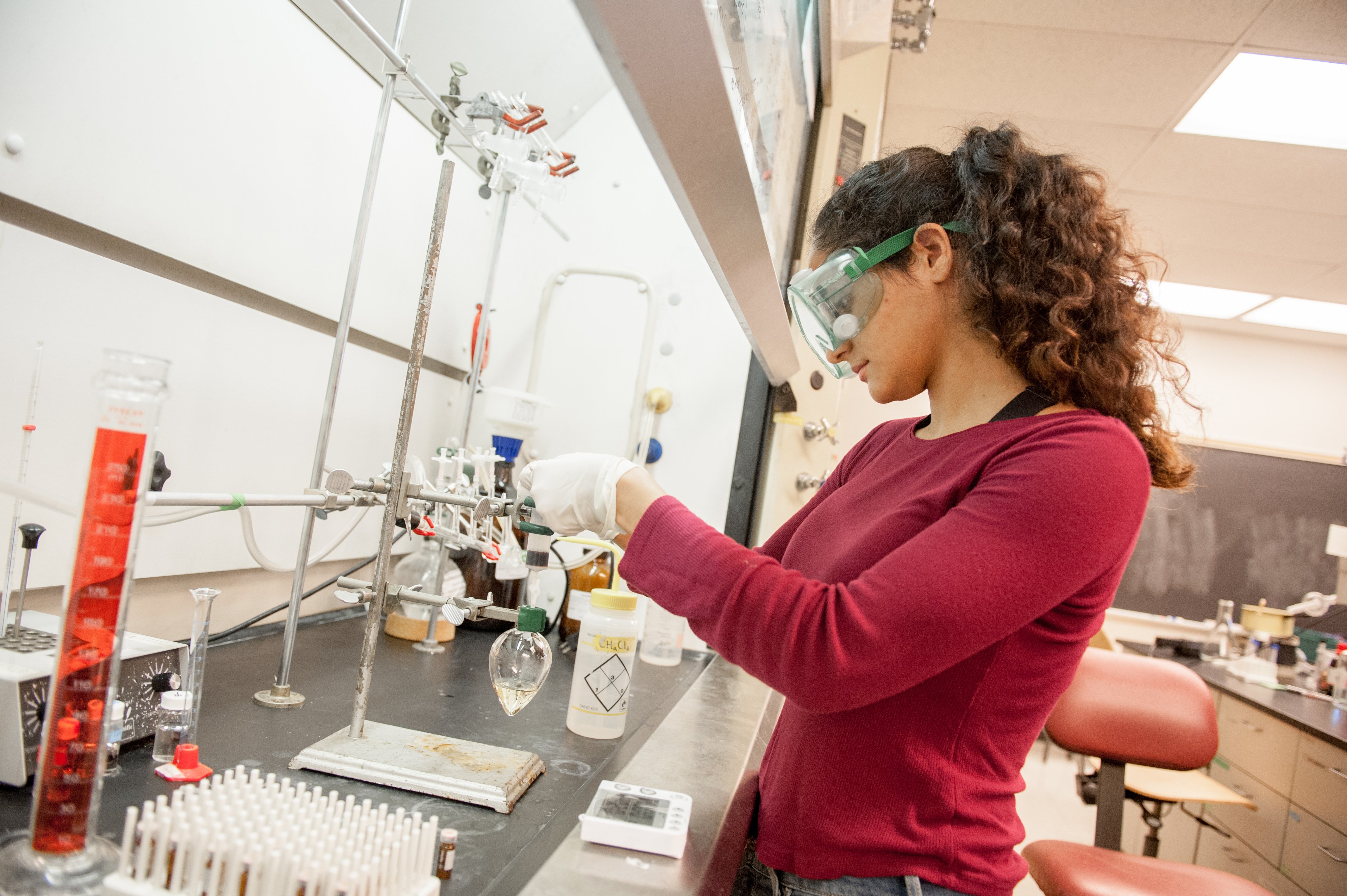 a person wearing safety goggles and gloves working in a lab