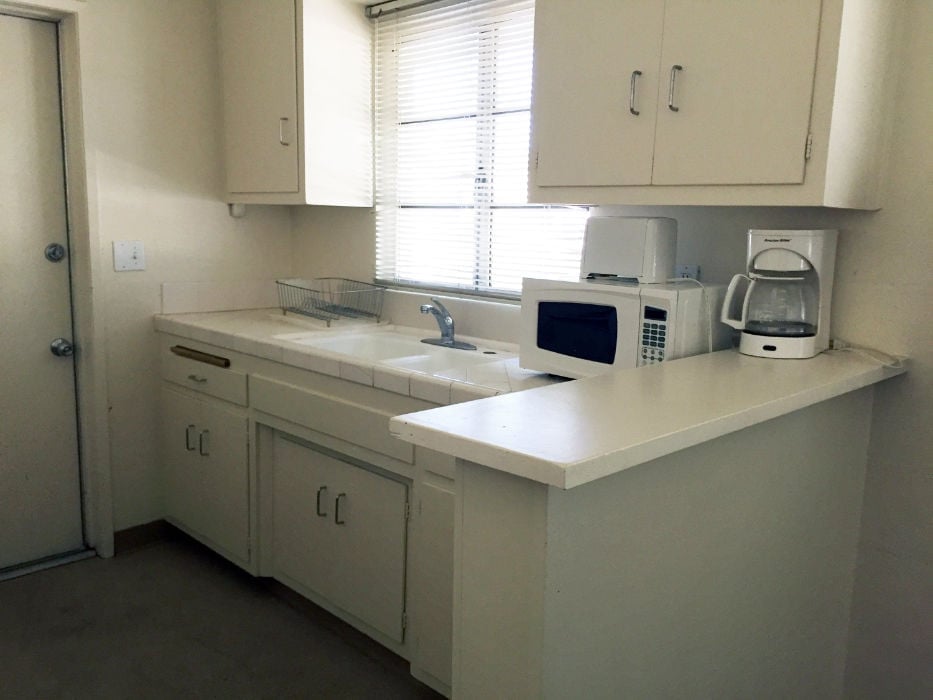 a kitchen with white cabinets and white appliances